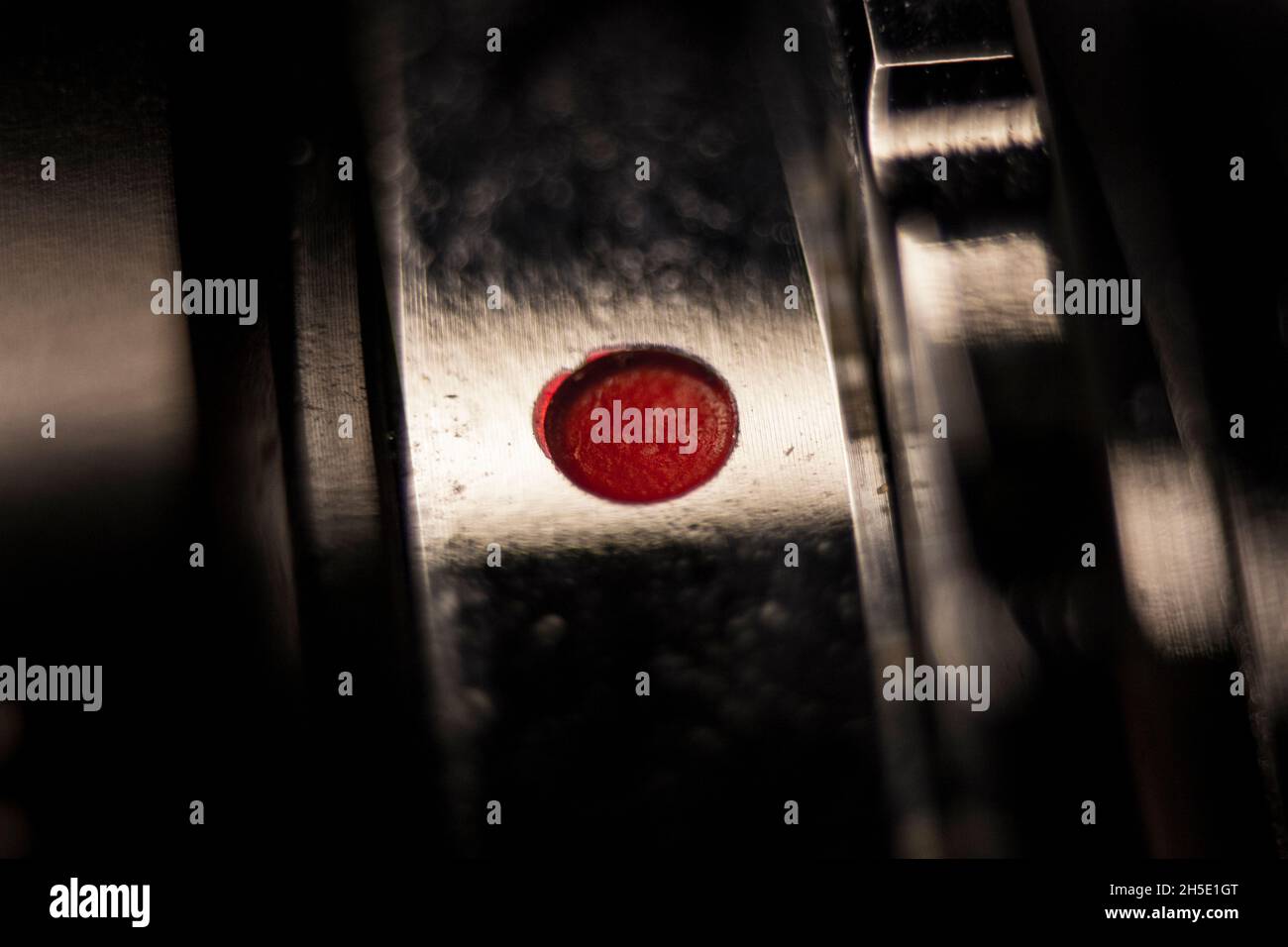 Fotografía macro con poca profundidad de campo del punto rojo de un adaptador de objetivo vintage a una cámara SLR digital de fotograma completo Foto de stock