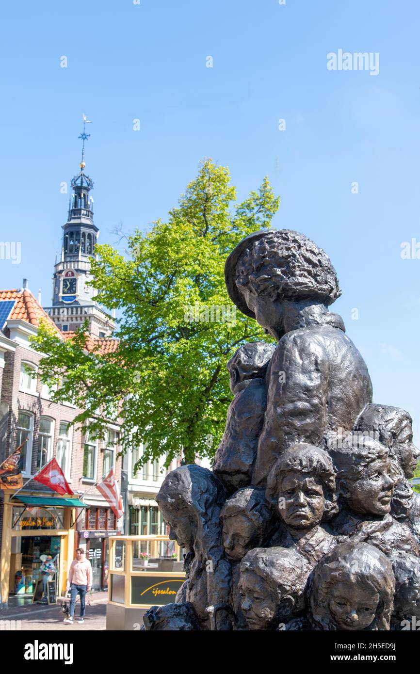 Alkmaar, Países Bajos-Junio 2021: Cerca de la estatua -madre de 1001 niños- por Truus Wijsmuller con aguja de la histórica Waag (peso edifdi Foto de stock