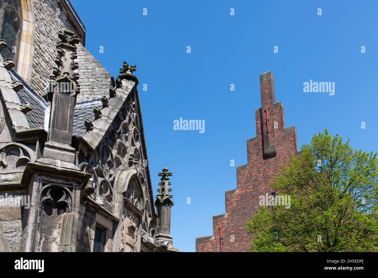 Alkmaar, Países Bajos junio 2021: Vista de los techos característicos de los edificios en la plaza de la iglesia, restaurante Stadskaffe Laurens y el coro del Fo Foto de stock