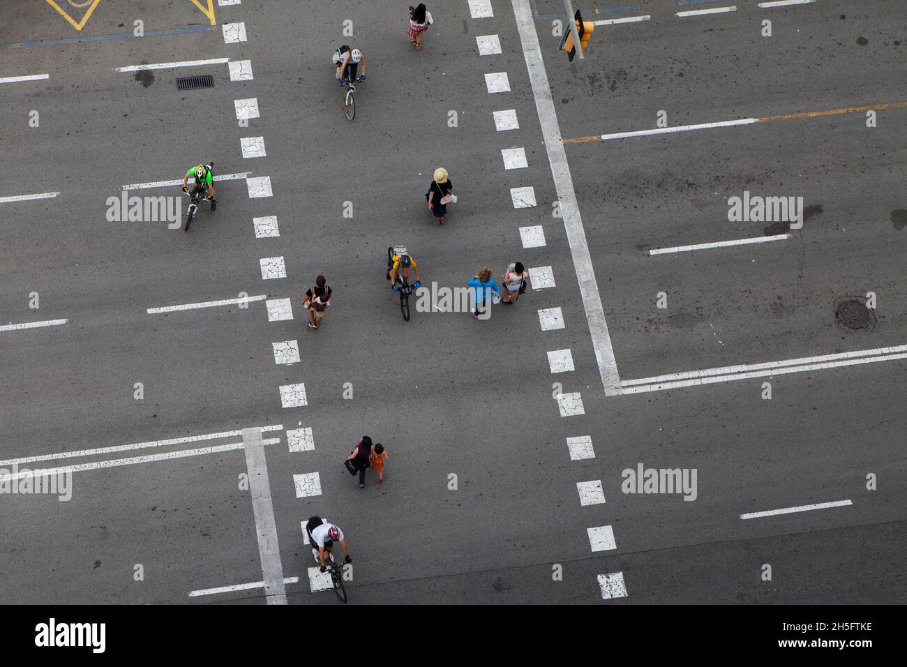 Fußgänger und Radfahrer (keine Erkennbarkeit) auf einer grauen Verkehrsstraße mit weißen gestrichelten Linien. Keine Autos. AUS der Vogelperspektive. Foto de stock