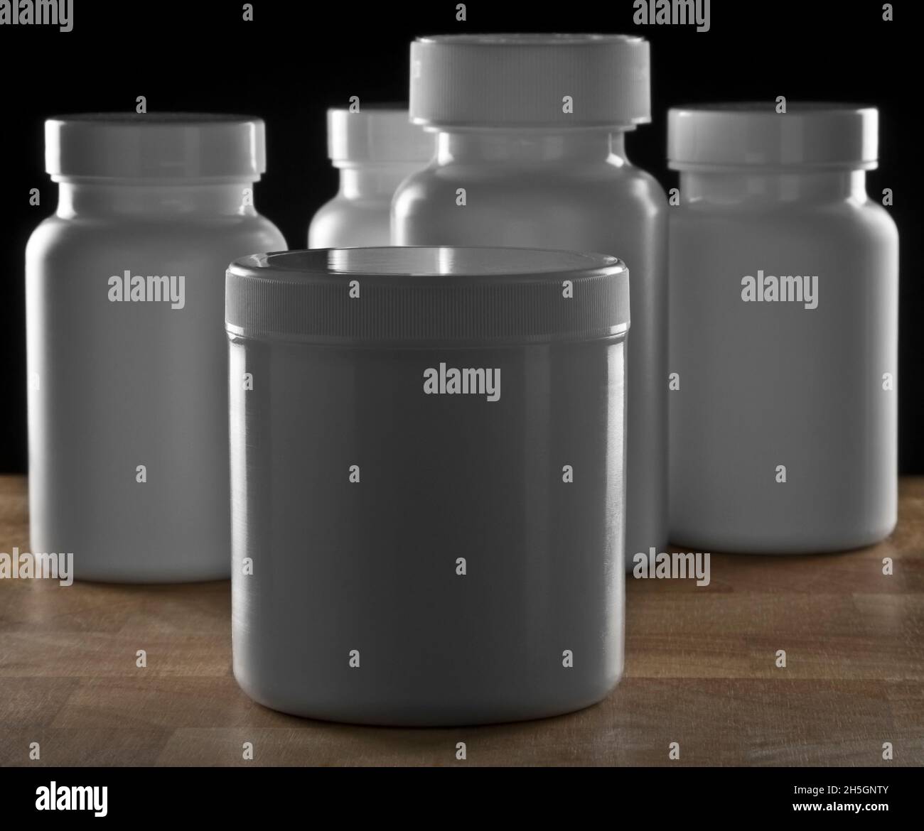 Botellas médicas de la píldora en banco de madera con fondo negro. Fotografías de alta calidad Foto de stock