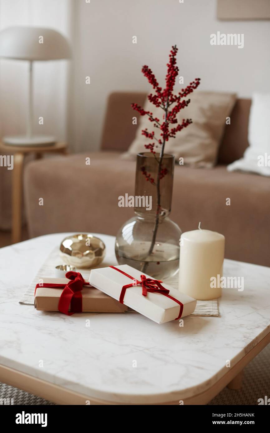Caja de regalo de Navidad con diseño de envoltorio de estilo minimalista,  vela y jarrón con algunas plantas en la mesa blanca. El concepto de eventos  de celebración y Fotografía de stock -