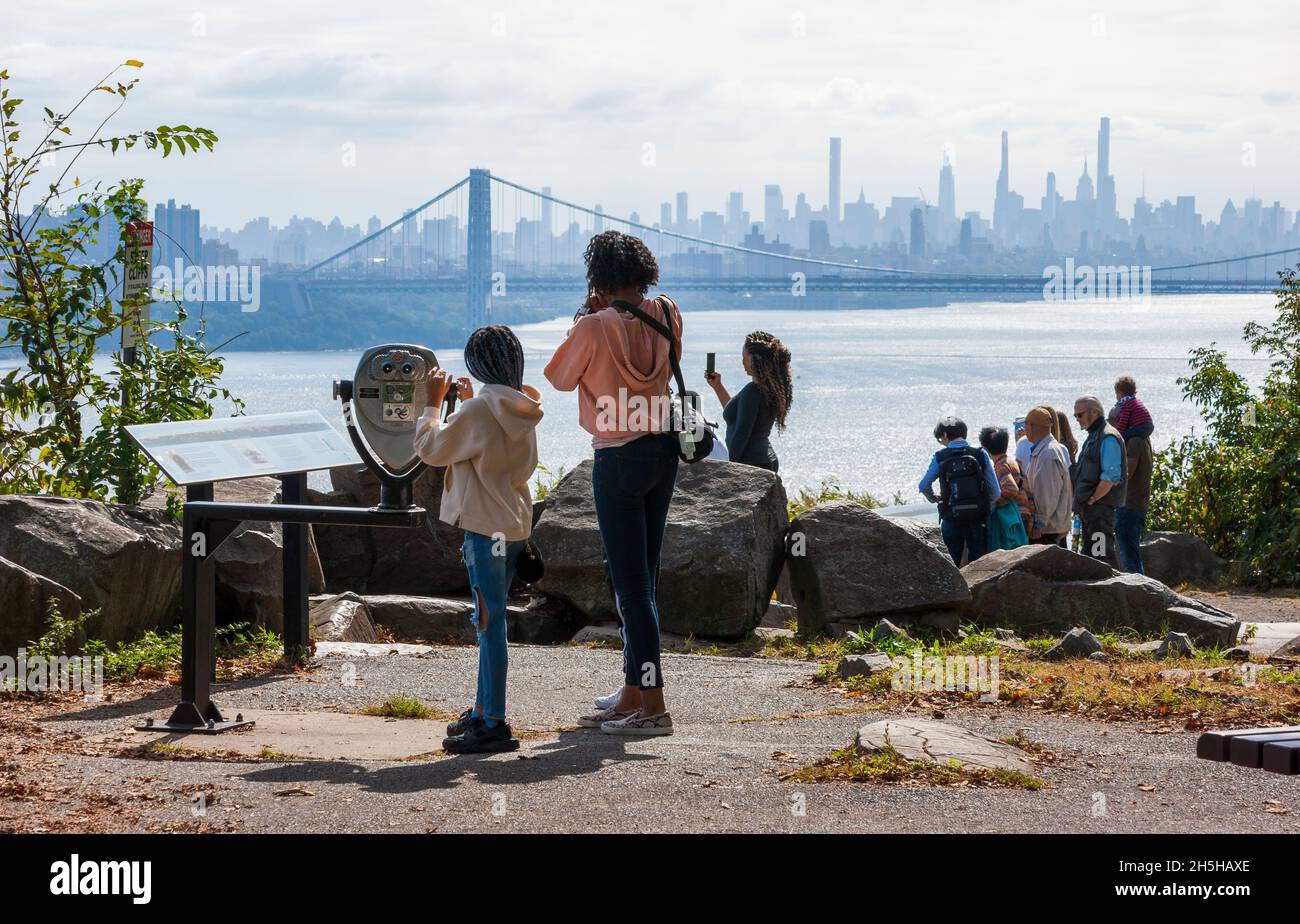 Los turistas disfrutan de la vista del puente George Washington y el horizonte de Manhattan desde el mirador Rockefeller en el Palisades Interstate Parkway. Foto de stock