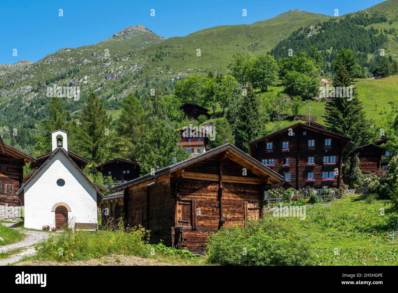 Aldea Eggen con la Capilla de la Madre de Dios y las montañas Risihorn y Chummelti en el fondo, Bellwald, Valais, Suiza Foto de stock