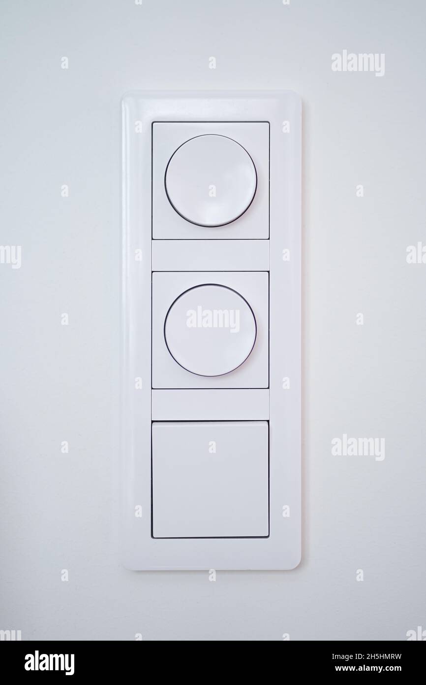 Interruptor de triple luz con regulador de intensidad en pared blanca  Fotografía de stock - Alamy