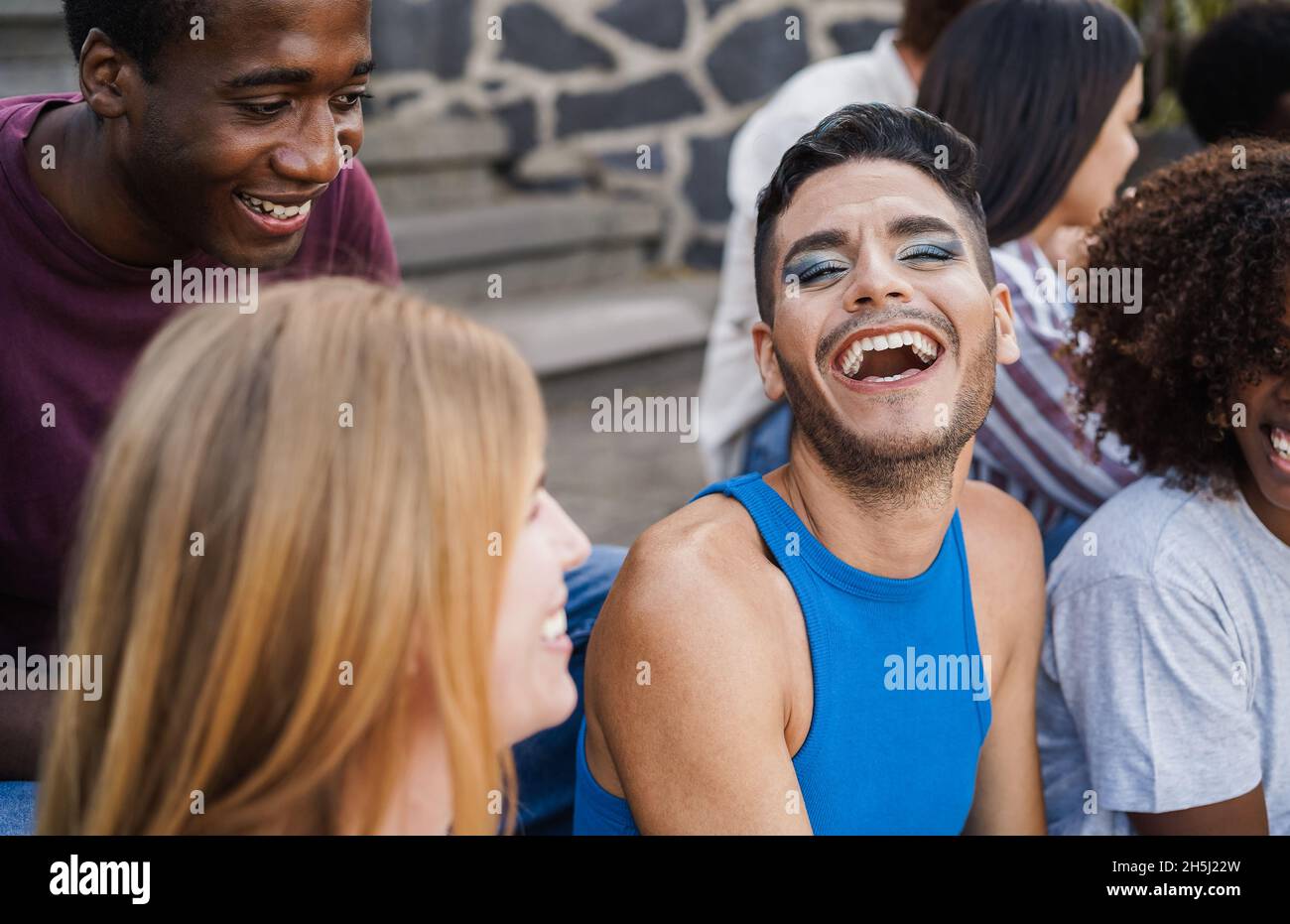 Gente joven diversa que se divierte al aire libre riendo juntos - foco en la cara del hombre gay Foto de stock