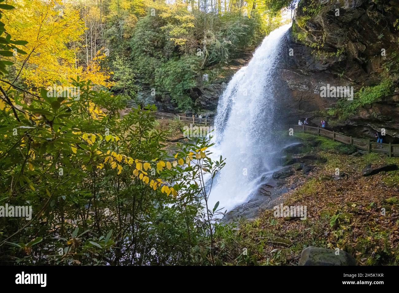 Los visitantes disfrutan del hermoso paisaje otoñal en Dry Falls, una cascada entre Highlands y Franklin en el oeste de Carolina del Norte. (EE. UU.) Foto de stock