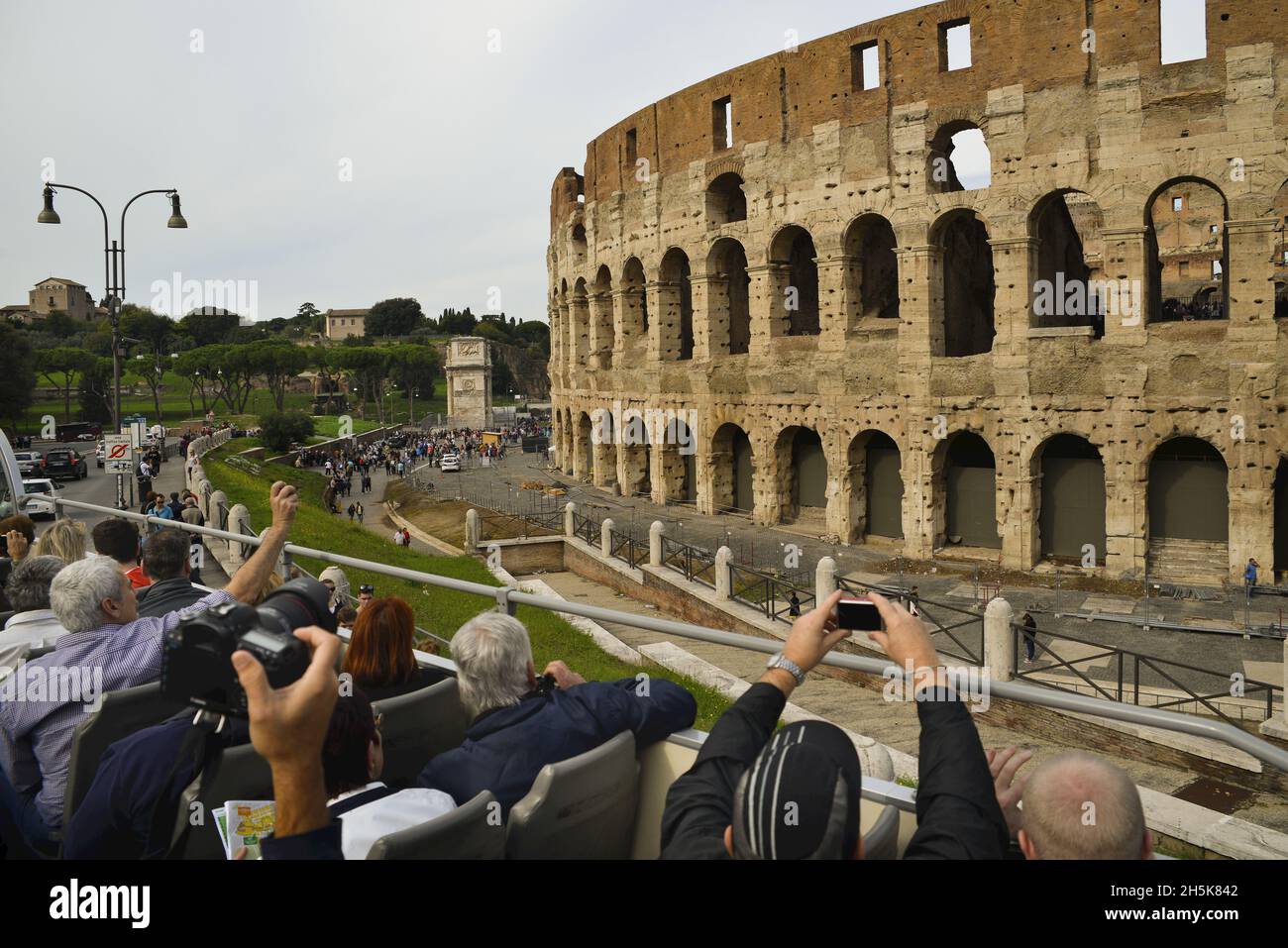 Vista tomada desde detrás de los turistas en un autobús turístico tomando fotos del Coliseo; Roma, Lazio, Italia Foto de stock