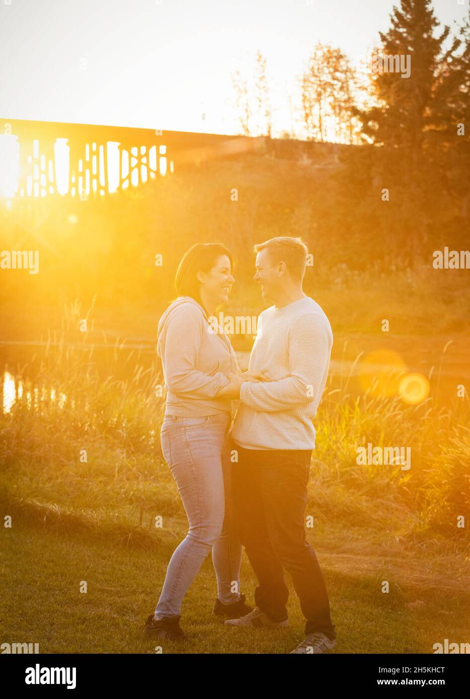 Una pareja de adultos de pie cara a cara y hablando juntos en un parque en otoño; St. Albert, Alberta, Canadá Foto de stock