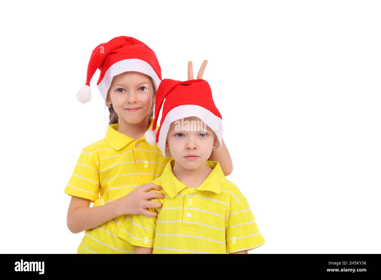 Lindos niños pequeños con gorras navideñas Foto de stock