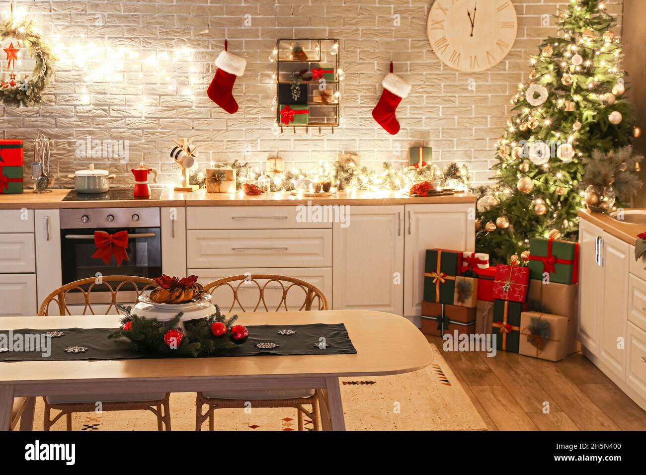 Interior de cocina moderna con árbol de Navidad, cajas de regalo,  decoración y mesa de comedor Fotografía de stock - Alamy
