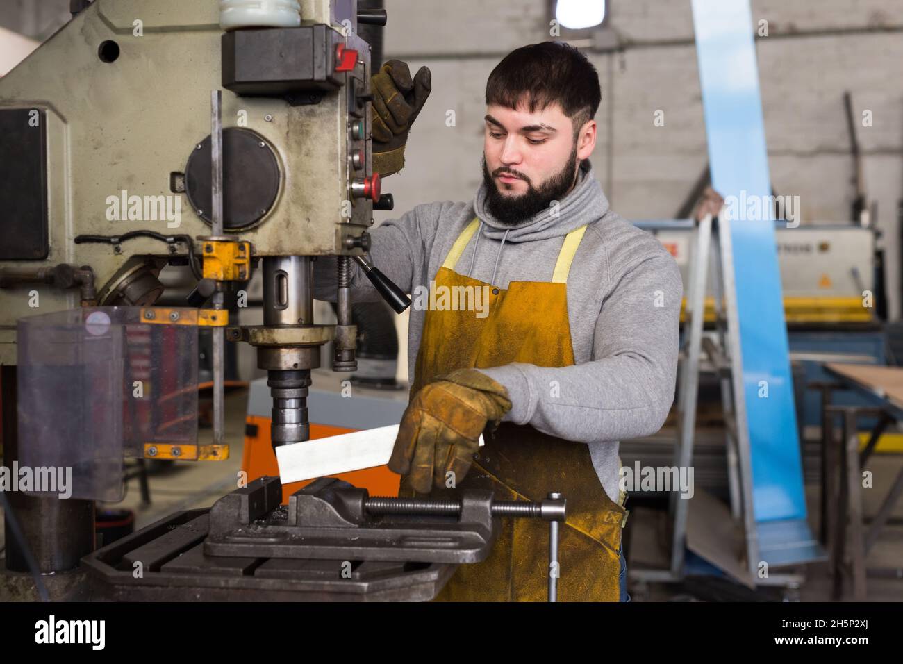 Hombre mecánico usando la máquina perforadora en el taller Fotografía de  stock - Alamy