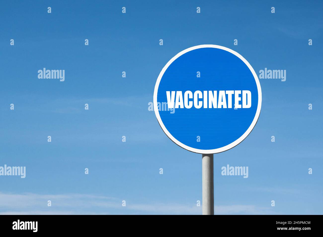 Signo vacunado en un marco azul redondo contra un cielo azul Foto de stock