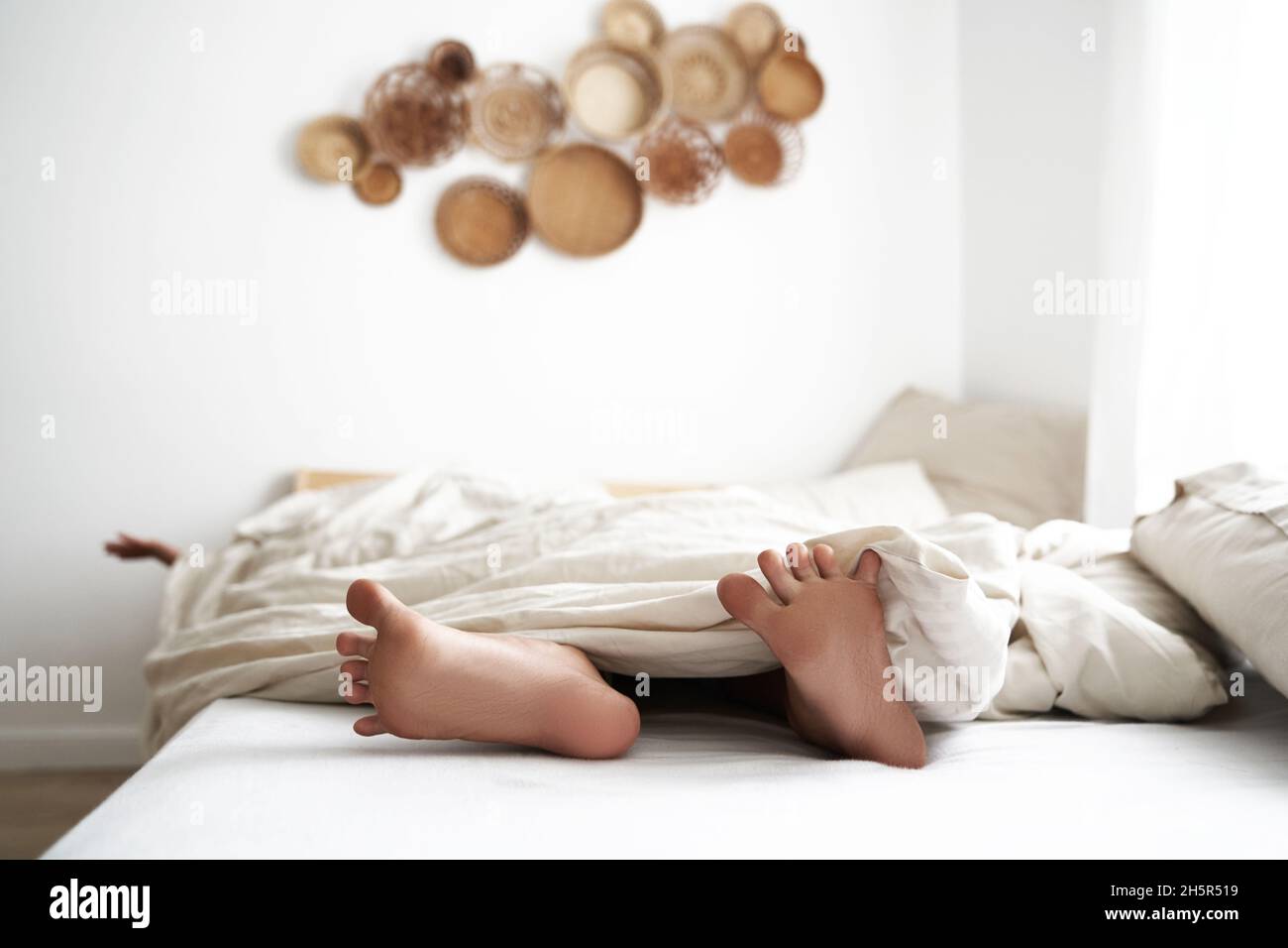 Bebé de 4 meses de edad sentado con los pies descalzos sobre una alfombra.  Juguetes en primer plano Fotografía de stock - Alamy