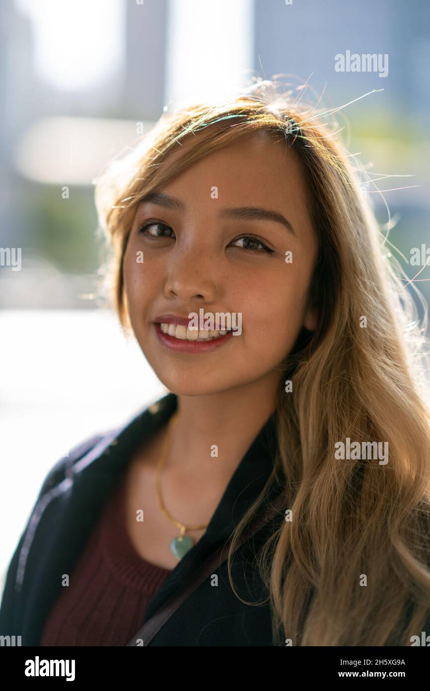 Primer plano retrato de una joven mujer filipina sonriente en el armario de otoño Foto de stock