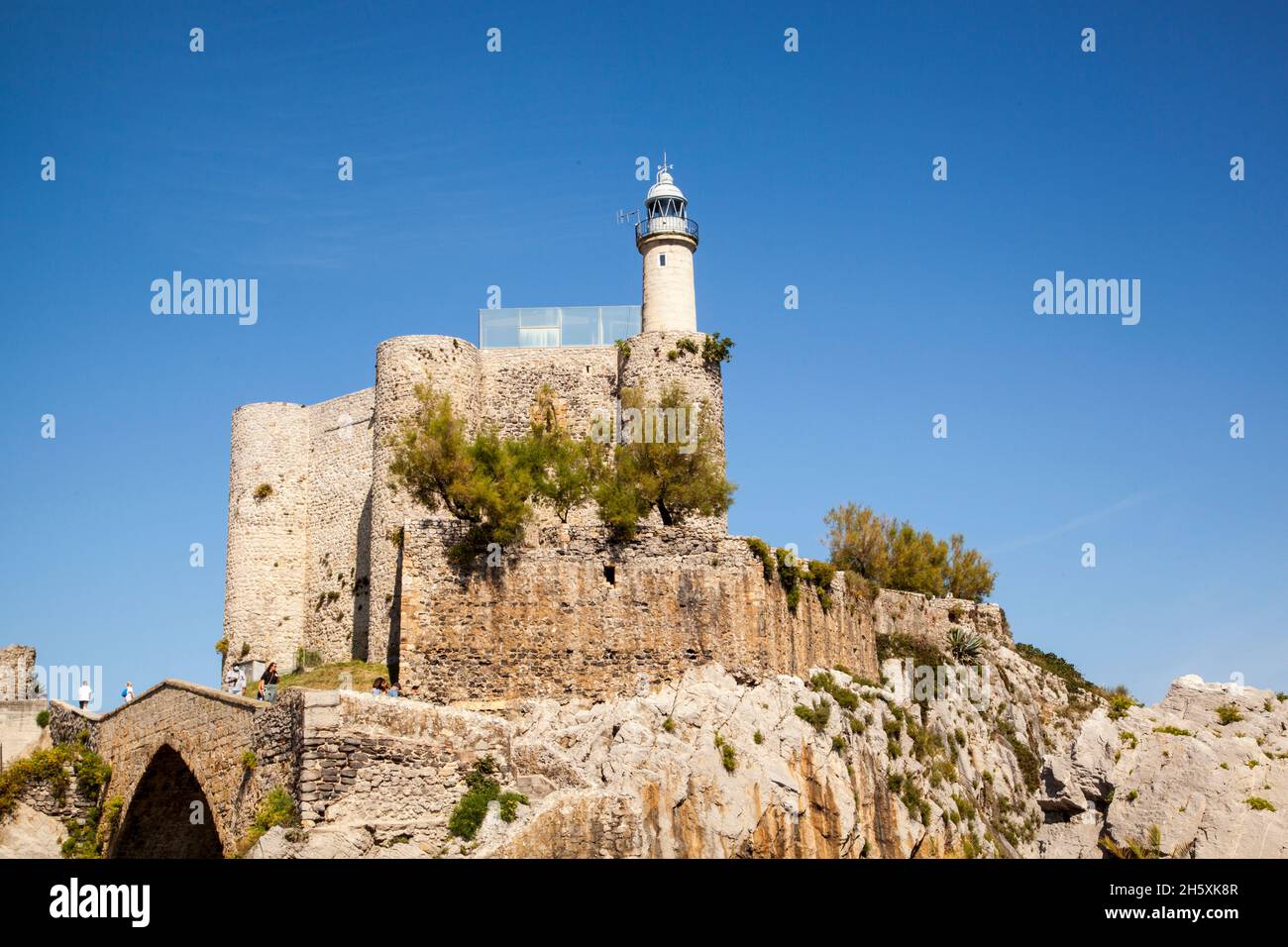 El castillo medieval de Santa Ana ahora alberga el faro en el puerto pesquero español y la localidad costera de Castro Urdiales Norte de España Foto de stock