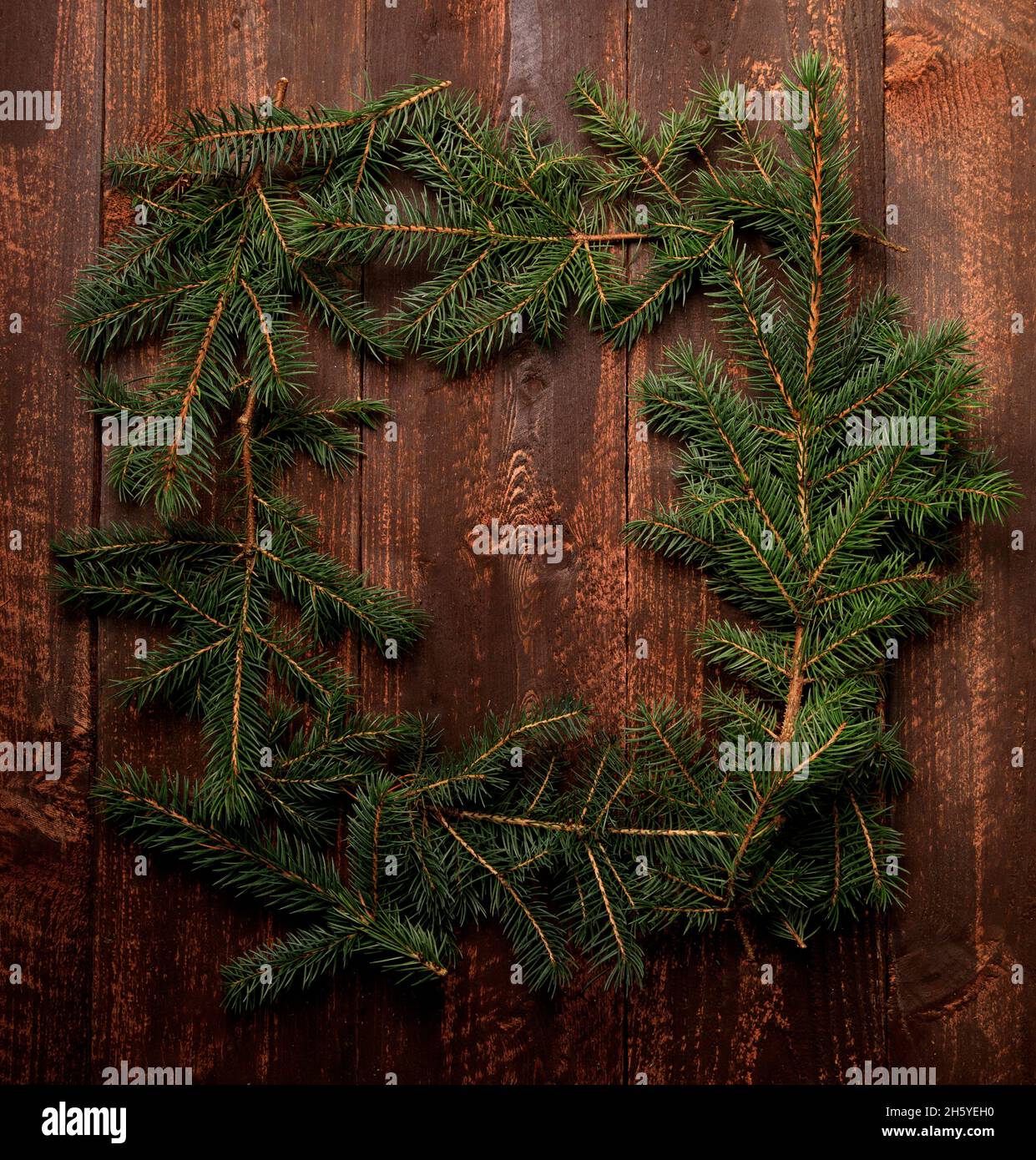Marco de la rama del abeto del árbol de Navidad en un fondo de madera oscuro Foto de stock