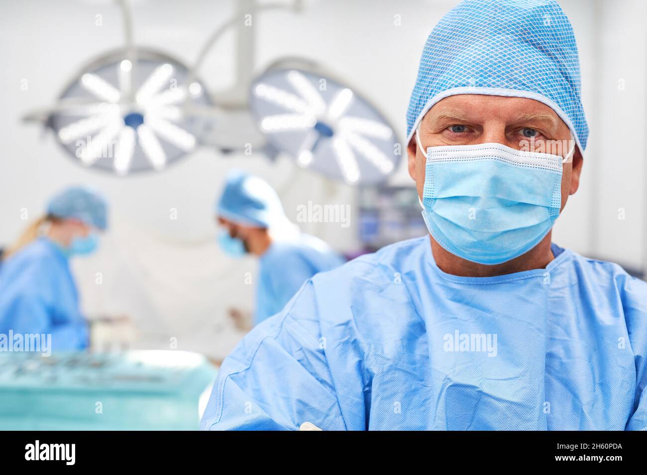 Médico jefe o cirujano con una máscara delante de su equipo en el quirófano Fotografía de stock - Alamy