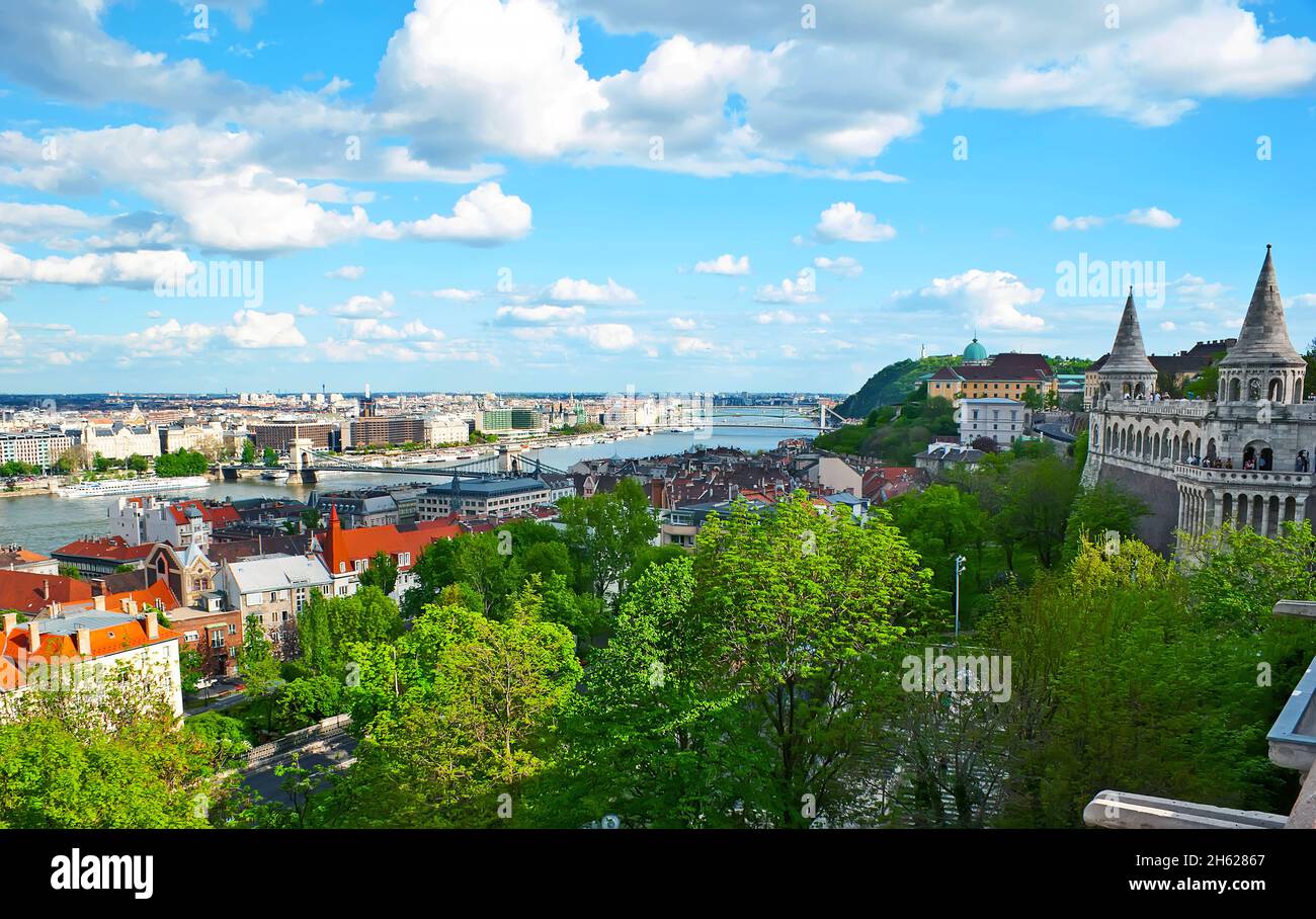 El Bastión de los Pescadores observa el exuberante parque verde en la ladera de la colina del Castillo de Buda, el río Danubio y los puentes, que conectan los distritos de Buda y Pest, B Foto de stock