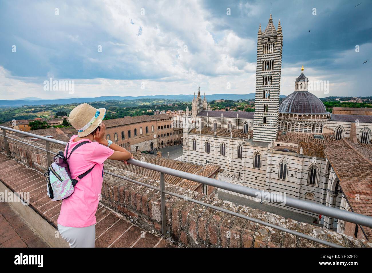 joven turista, de 10 años, observa desde arriba la catedral santa maria assunta,siena,toscana,italia Foto de stock