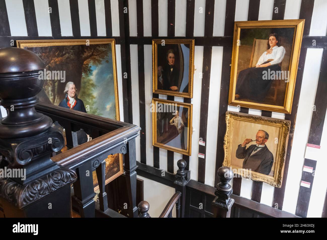 inglaterra, southampton, casa tudor y jardín museo, vista interior que muestra escalera de madera y obras de arte Foto de stock