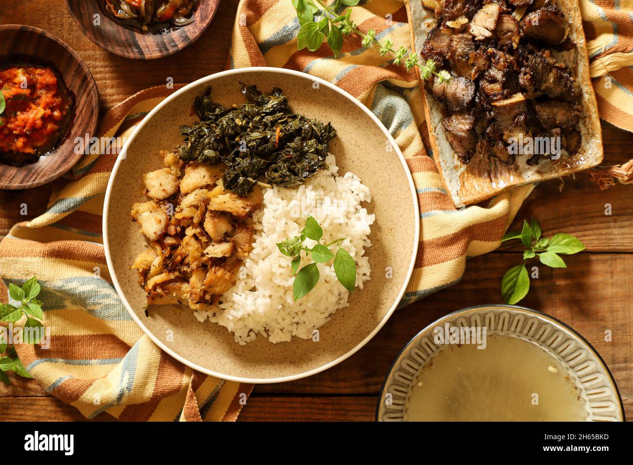 Se'i pollo. Plato de pollo ahumado de Nusa Tenggara Timur, servido con arroz y hojas de yuca Foto de stock