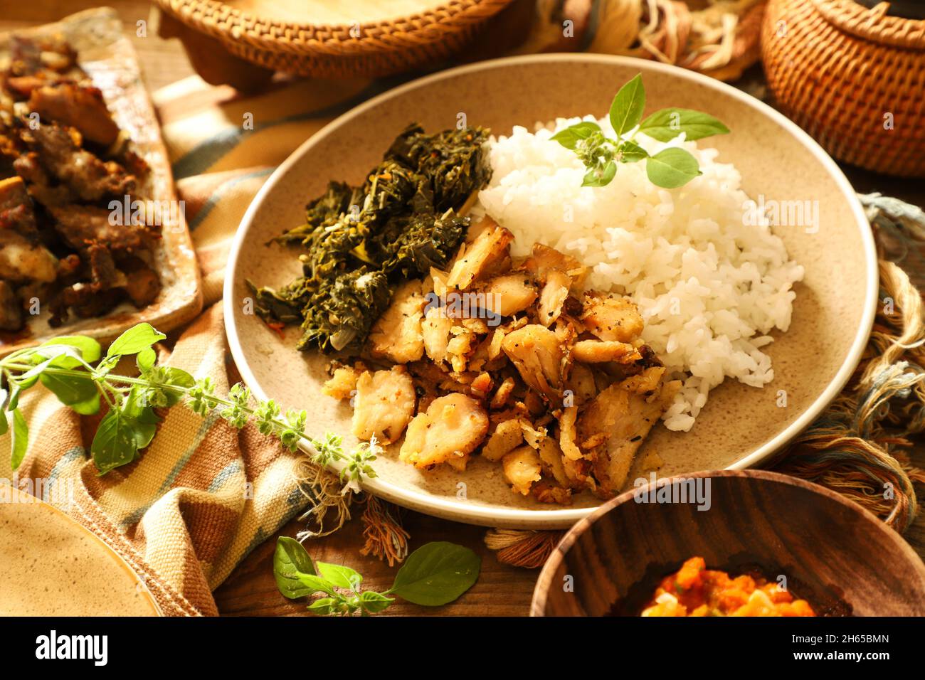 Se'i pollo. Plato de pollo ahumado de Nusa Tenggara Timur, servido con arroz y hojas de yuca Foto de stock