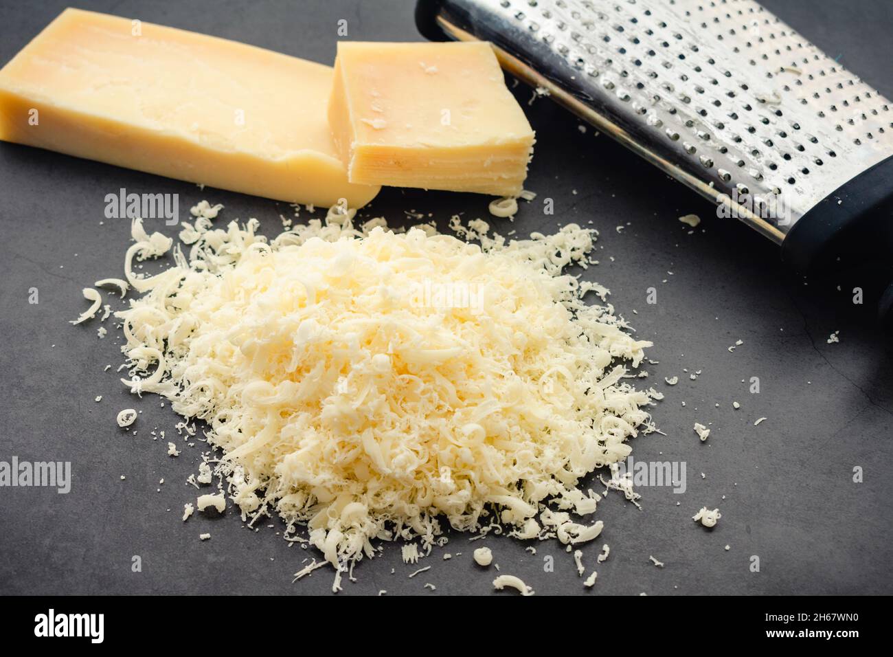 https://c8.alamy.com/compes/2h67wn0/queso-parmesano-rallado-con-rallador-de-cajas-montones-de-queso-parmesano-rallado-finamente-2h67wn0.jpg