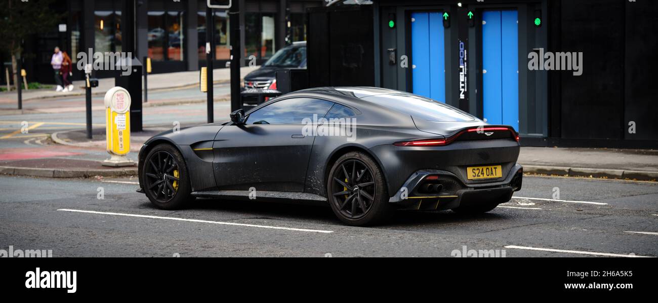 estático Gastos de envío Cartero Aston Martin coche deportivo en la calle color negro mate coupé británico  fabricado Fotografía de stock - Alamy