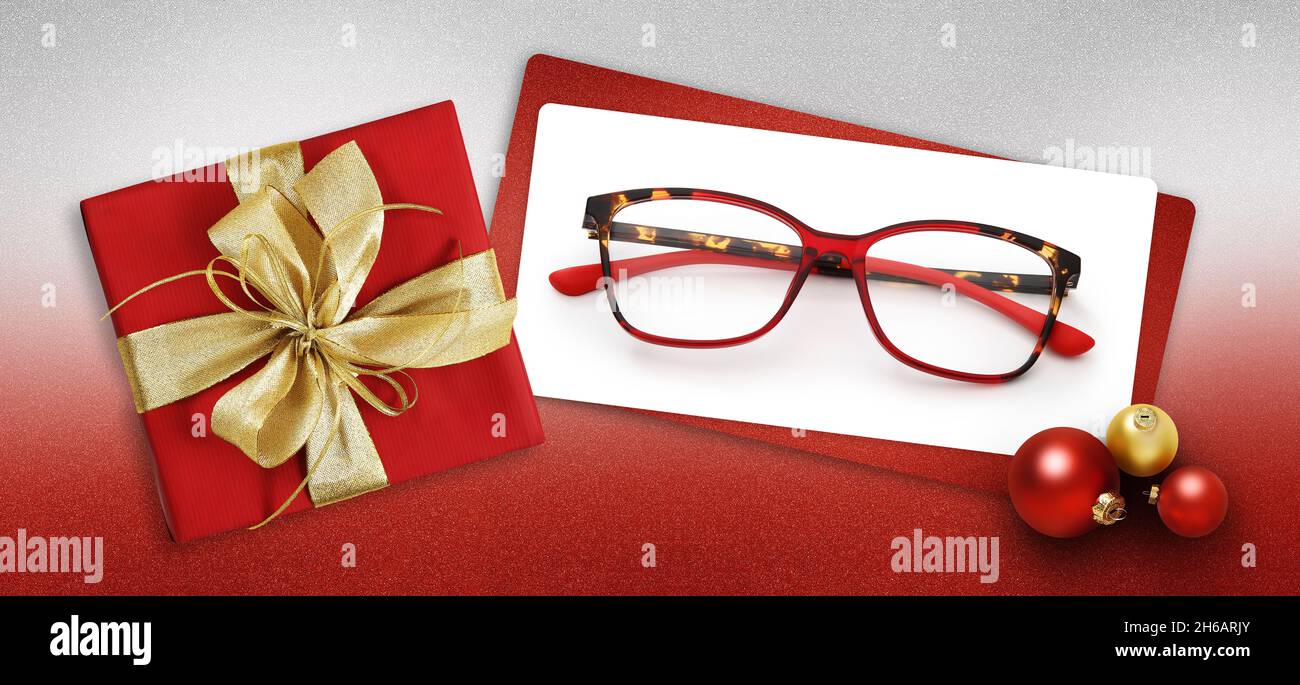 gafas tarjeta de regalo de navidad, caja roja con lazo dorado brillante de  la cinta, entrada blanca y gafas cerca de bolas de navidad sobre fondo rojo  brillante, plantilla para Fotografía de