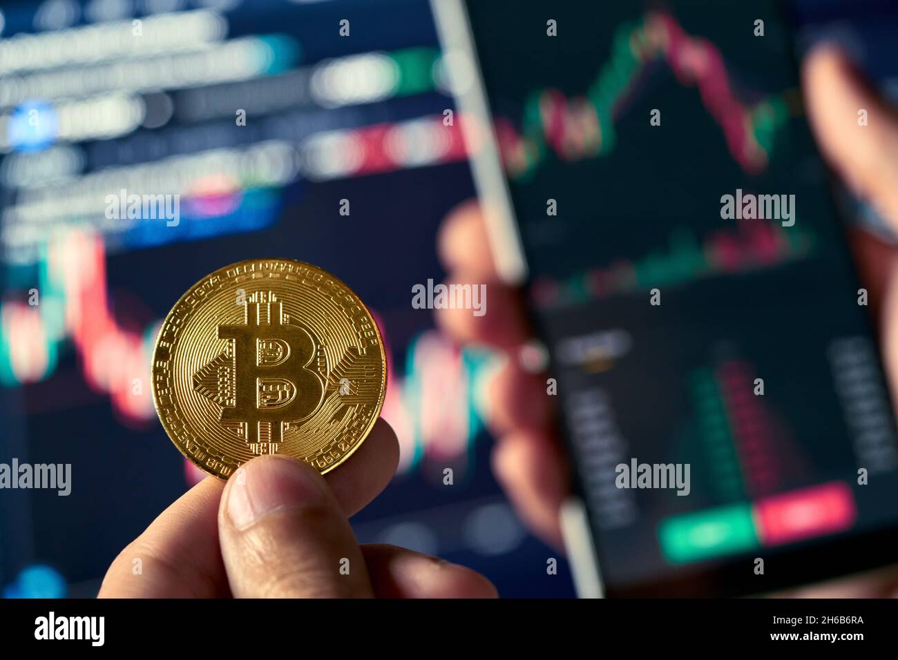 Inversor comerciante que sostiene teléfono y moneda de compra bitcoin en el mercado de cripto.. Foto de stock