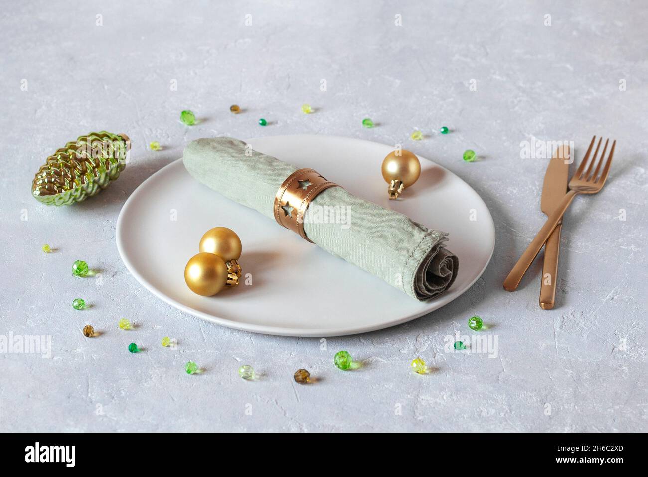 Plato, servilleta y cubiertos decorados para la cena de Navidad, colores dorados y verdes, idea para la tarjeta de Navidad Foto de stock