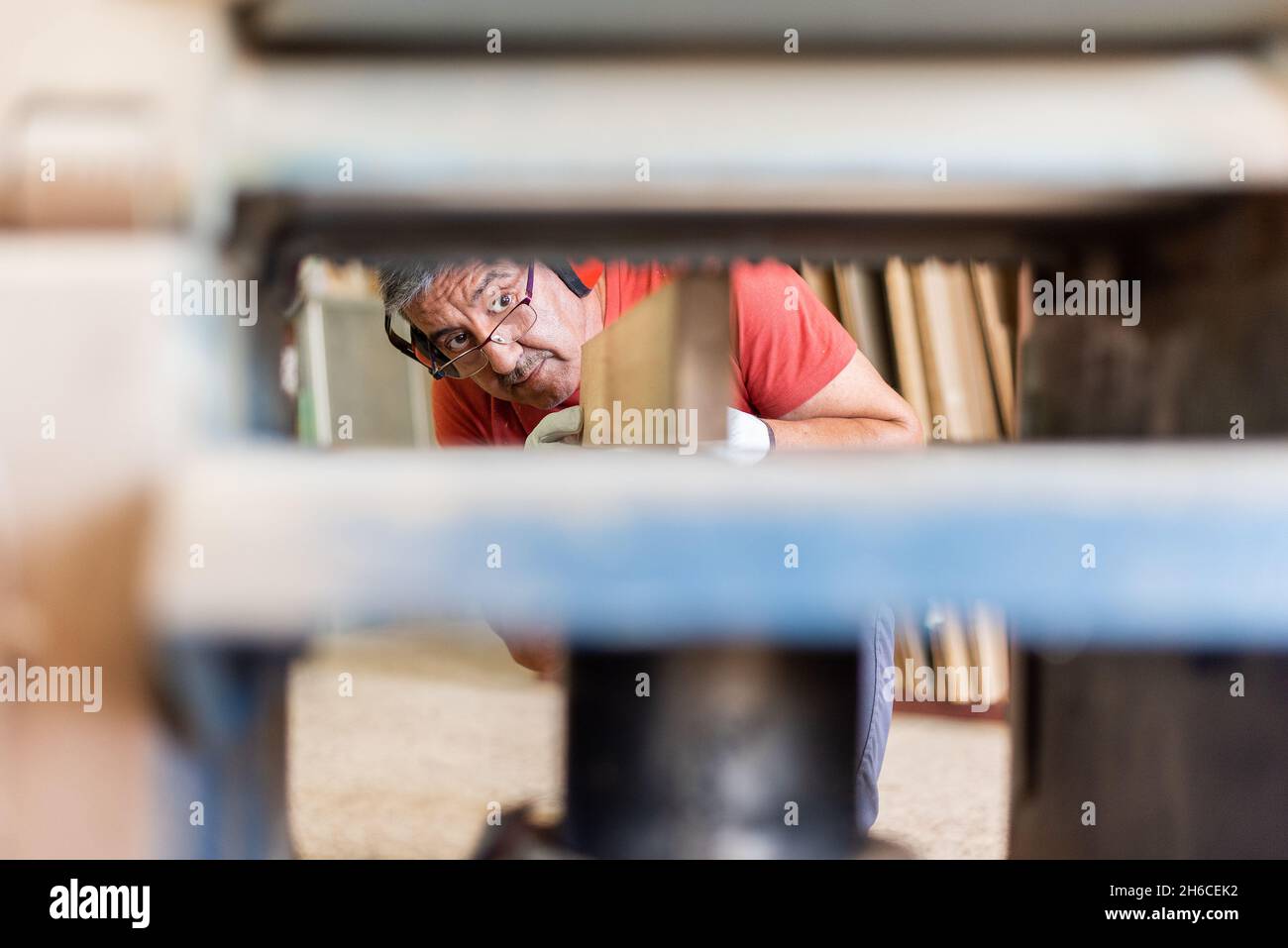 Hombre en camiseta roja que trabaja con un perfilador de madera Fotografía  de stock - Alamy