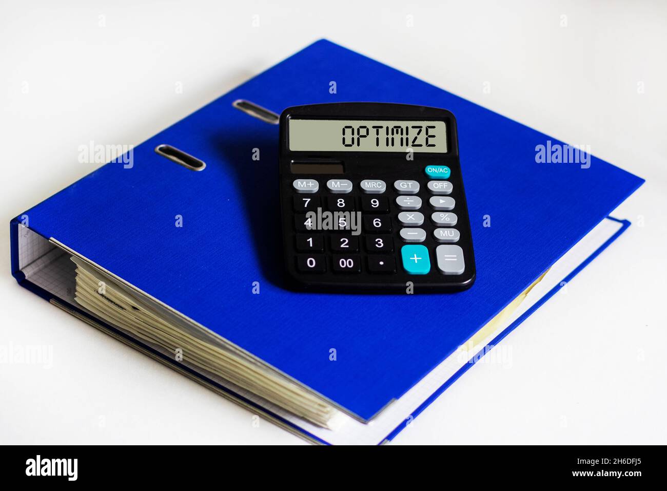 Calculadora con optimización de texto en la pantalla y con una carpeta azul  para documentos sobre fondo blanco Fotografía de stock - Alamy