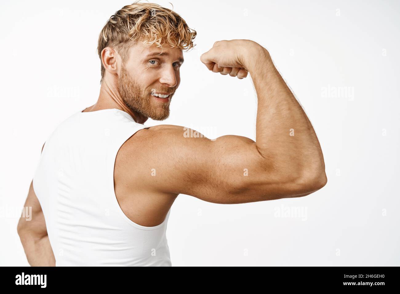 Sportsman flexionan bíceps, mostrando el brazo fuerte y sonriendo  satisfechos después de entrenar en el gimnasio, fondo blanco Fotografía de  stock - Alamy