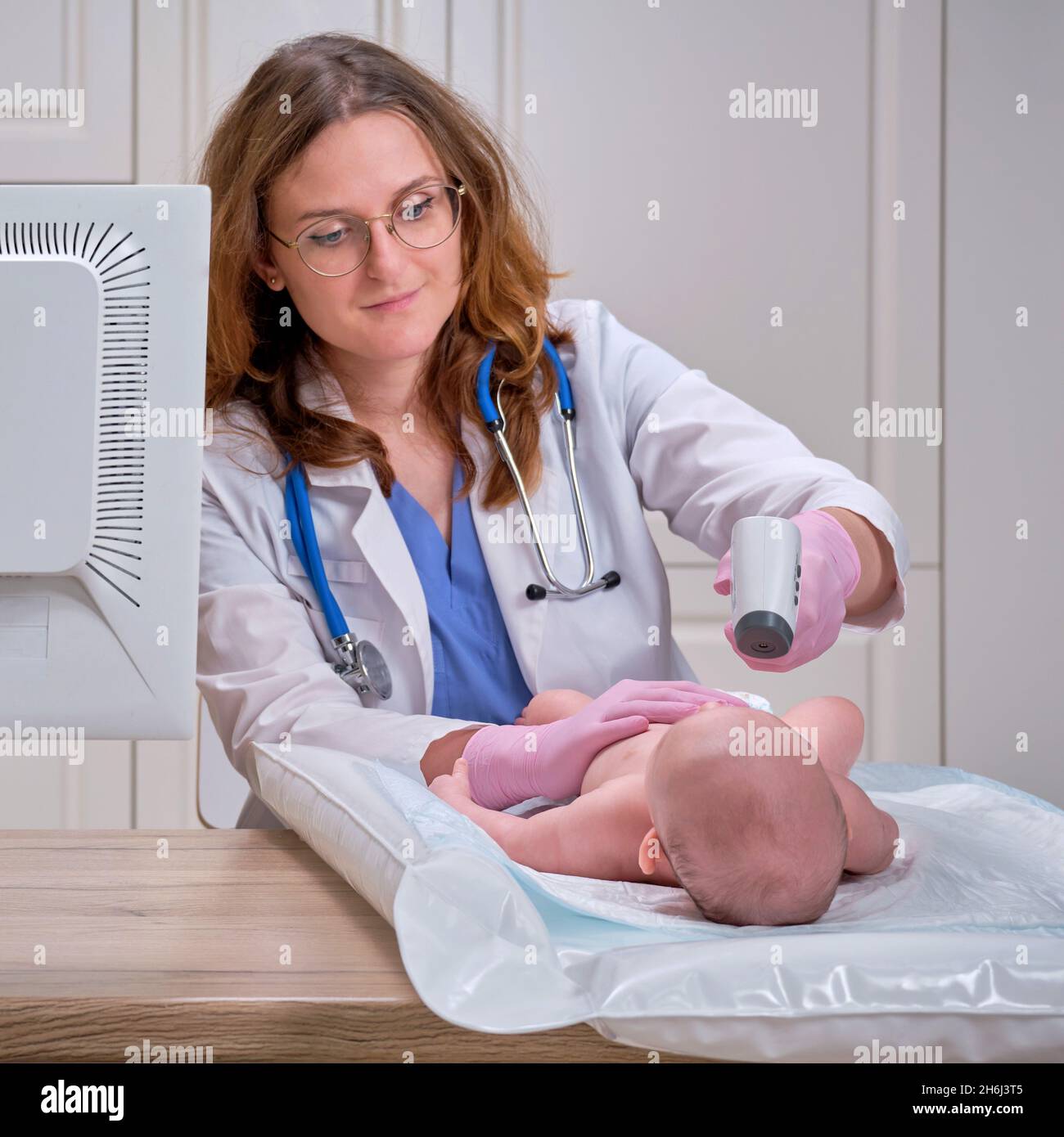 El médico revisa la temperatura del bebé recién nacido con un termómetro.  Una enfermera uniforme mide la fiebre del niño con un termómetro Fotografía  de stock - Alamy