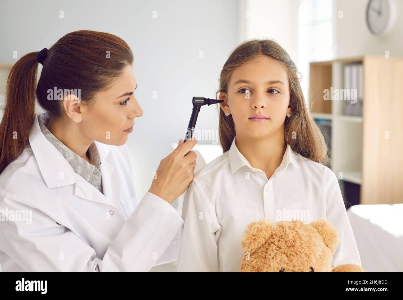 Otorrinolaringólogo que hace el examen del ENT de niño durante el chequeo médico en su oficina Foto de stock