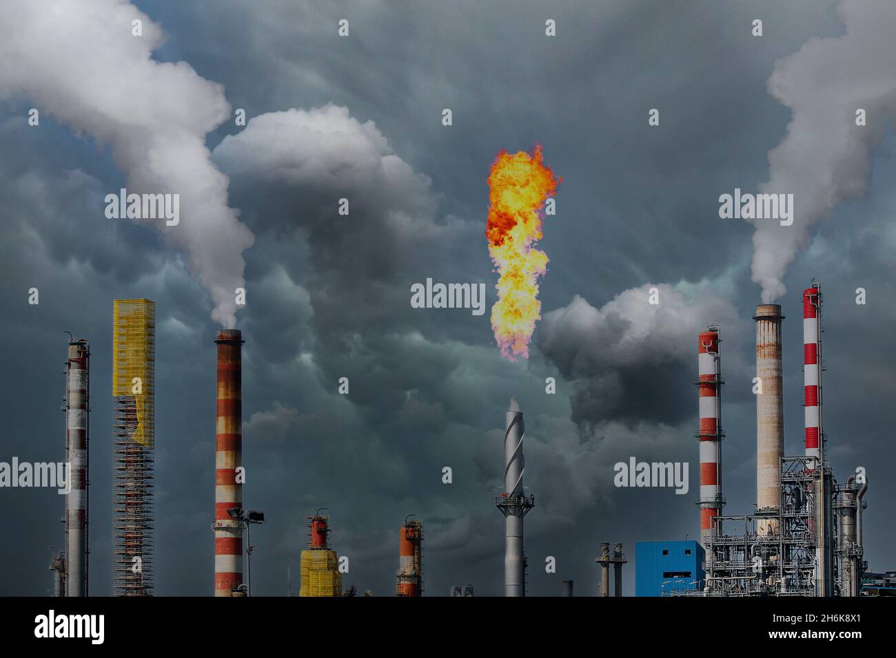 Columnas de humo y gases de combustión antorcha en una gran refinería de petróleo Foto de stock