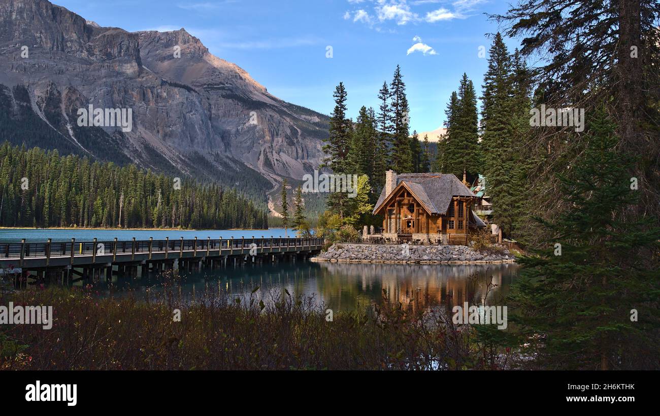 Hermosa vista del Lago Emerald en el Parque Nacional Yoho, Columbia Británica, Canadá en la luz de la tarde con edificio de madera y puente en otoño. Foto de stock