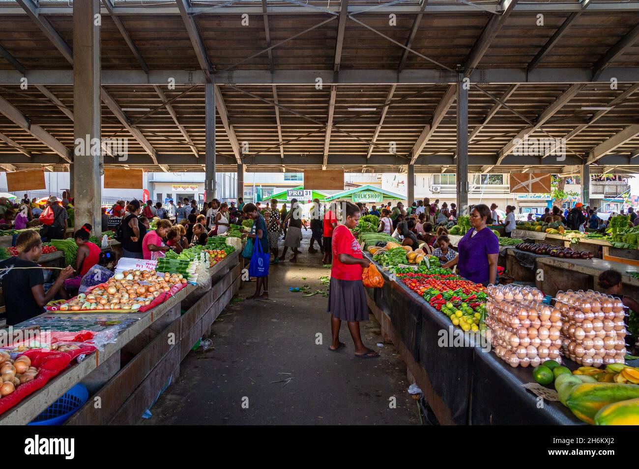 HONIARA, ISLAS SALOMÓN - 11 de enero de 2016: Los lugareños echan un vistazo a los pasillos de productos frescos que se venden en el edificio principal del mercado central de Honiara, el más grande Foto de stock