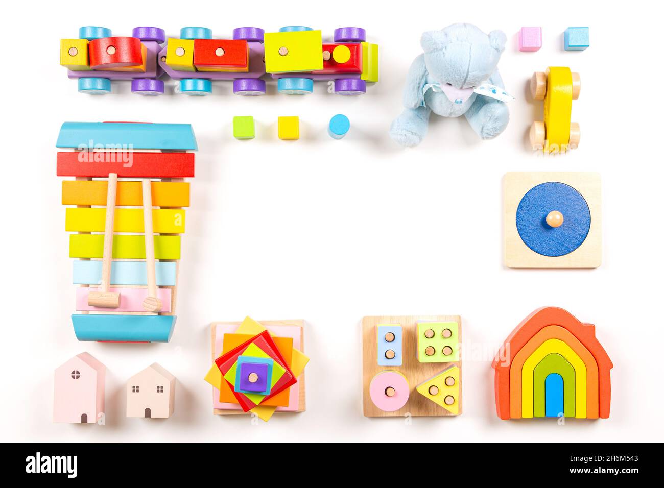Marco de juguetes para niños pequeños. Coloridos juguetes educativos y de madera Montessori para niños dispuestos sobre fondo blanco. Vista superior, diseño plano Foto de stock