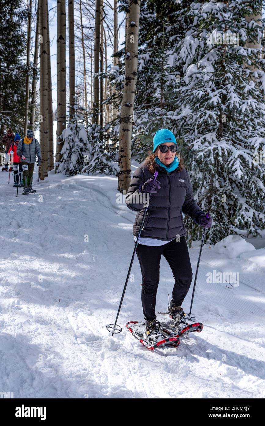 Avenida Alrededores puesto Una mujer que lleva un gorro turquesa y zapatos de nieve de ropa deportiva  de invierno en un sendero cuidado en las montañas de San Juan en el Chama  Chile Ski Classic