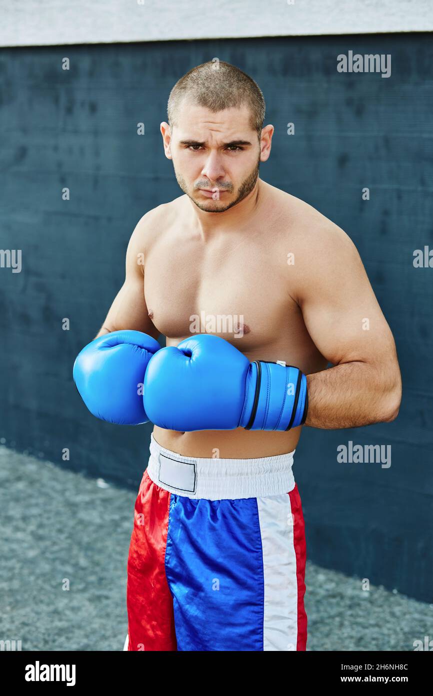 Un hombre en un ring de boxeo con un hombre con un pantalón corto blanco y  una camiseta que dice boxer.