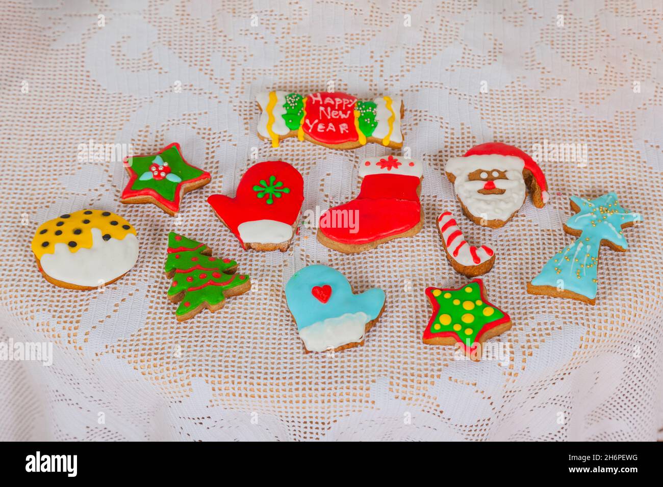 Galletas caseras de pan de jengibre decoradas en un estilo navideño. Mini cupcakes de postre navideños festivos de temporada en los símbolos decorativos tradicionales de los hombres Foto de stock