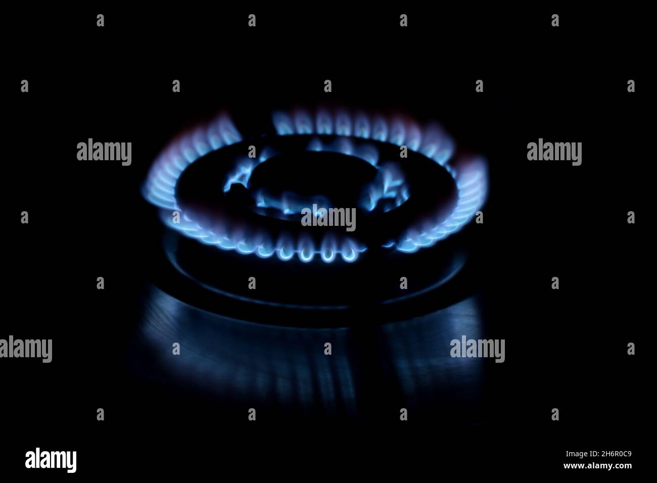 cocina estufa de gas con llama azul sobre fondo oscuro Foto de stock