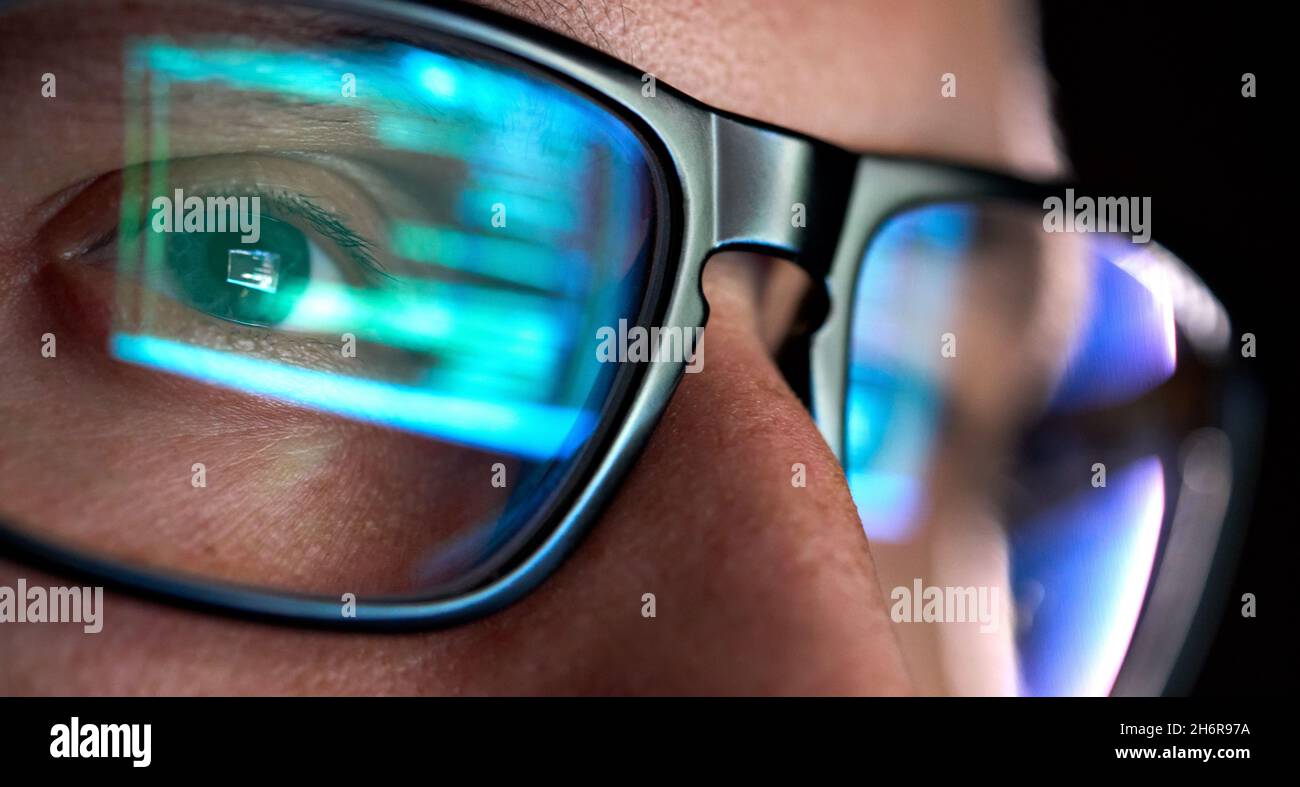 Codificador de desarrollador mirando en la computadora, código de programación que refleja en gafas. Foto de stock
