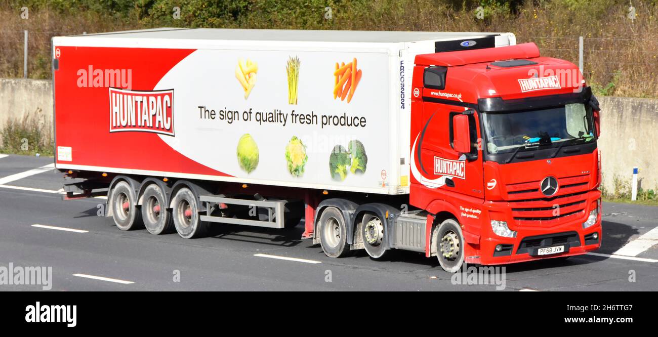 Huntapac negocio cadena de suministro de alimentos hgv camión conductor de alimentos frescos productos de la empresa publicidad en el lado del remolque articulado y vista frontal de la autopista del Reino Unido Foto de stock