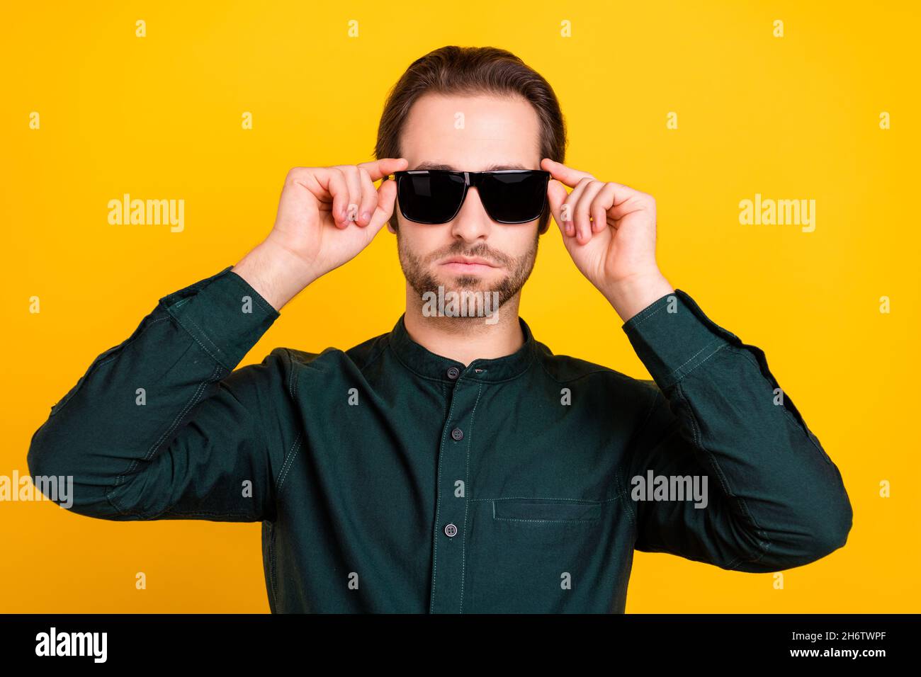 Foto de joven seguro atractivo vestido elegante ropa informal brazos oscuro  gafas aisladas color amarillo fondo Fotografía de stock - Alamy