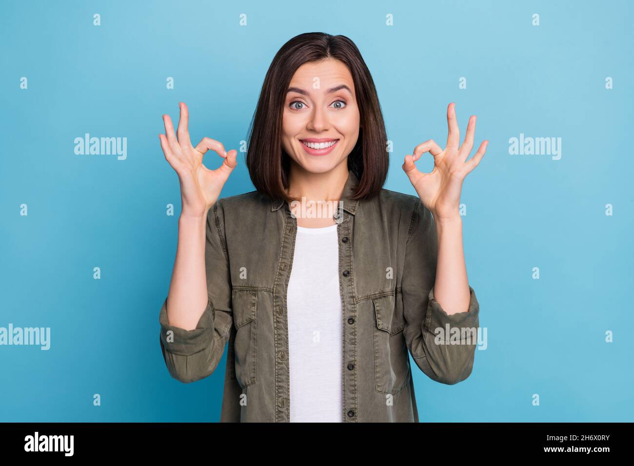 Foto de la señora promotora mostrar el símbolo de okey demostrar excelente  toma de decisiones ropa caqui aislado sobre fondo de color azul Fotografía  de stock - Alamy