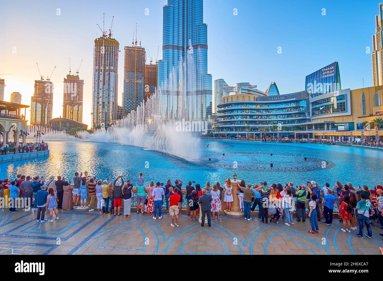 DUBAI, EAU - 3 DE MARZO de 2020: Multitud de personas observa el espectáculo de la Fuente de Dubai desde la plataforma de observación del puente Souk Al Bahar sobre el lago Burj Khalifa, en M Foto de stock